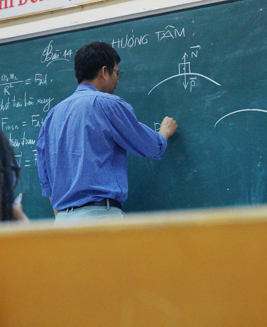 Menulis rumus di papan tulis kelas